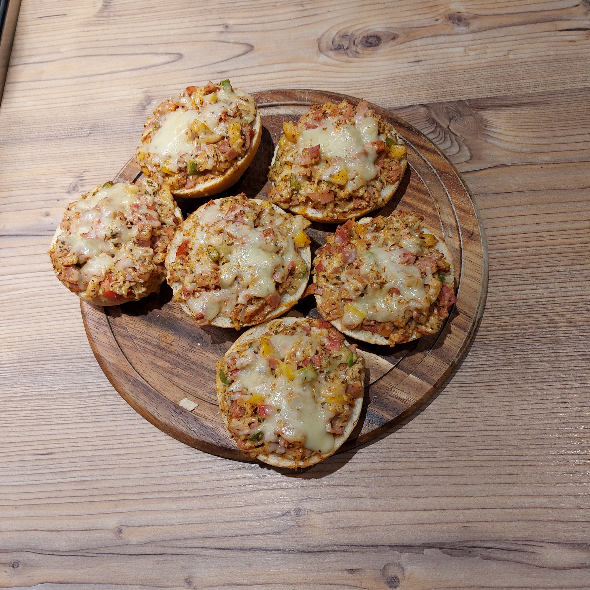 6 Pizzasemmeln auf einem Schneidebrett aus Holz