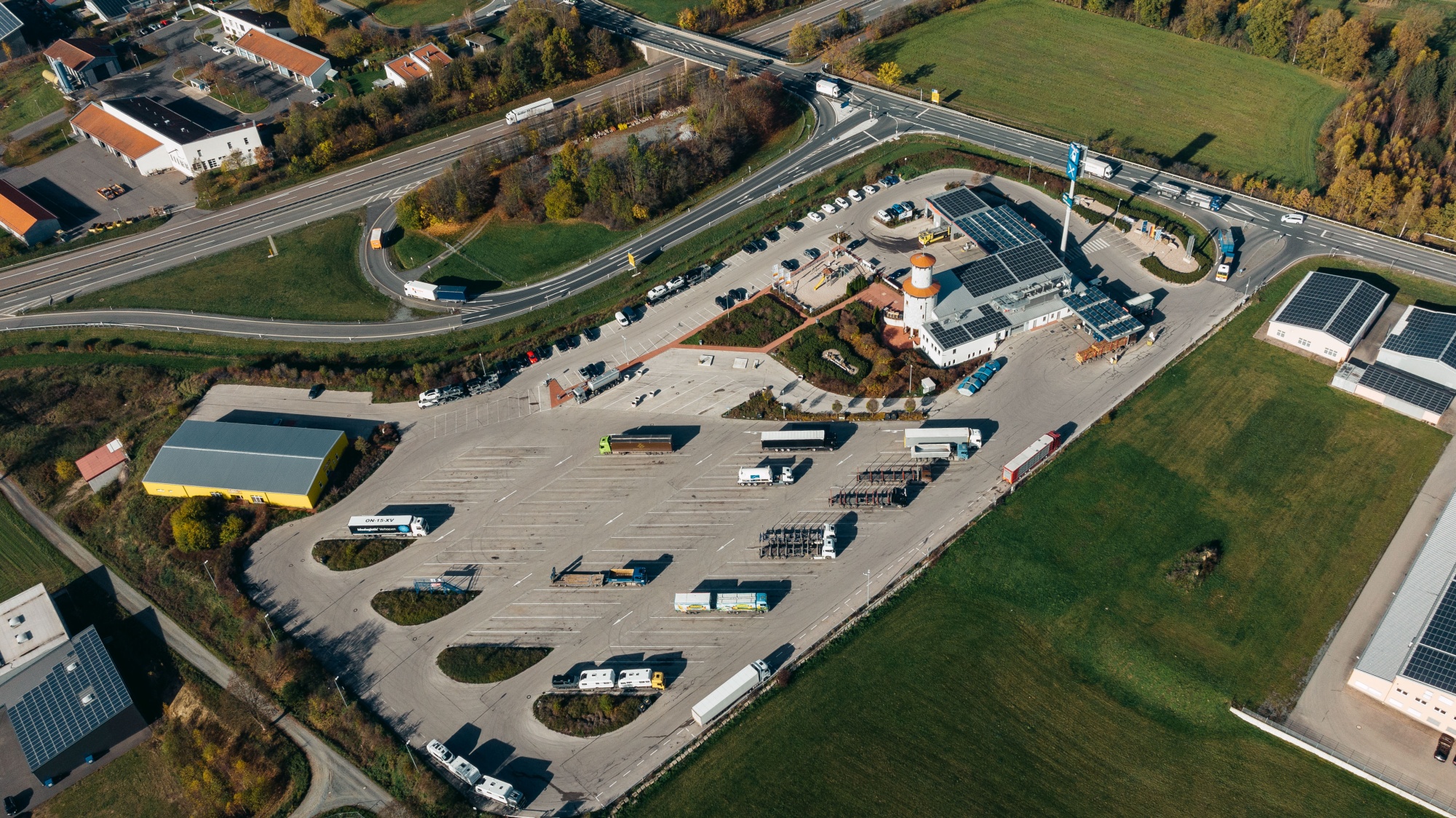 Der Autohof Bergler aus der Vogelperspektive. Links das große Parkplatzangebot für LKWs, rechts das Gebäude mit Tankstelle, Restaurant und Bistro.